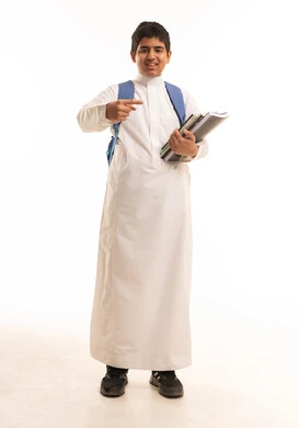 طالب سعودي بالثوب الأبيض يحمل كتب مدرسية
