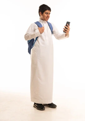 Saudi Schoolboy in Thobe Using Smartphone