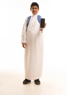 طالب سعودي بالثوب التقليدي يحمل هاتفاً ذكياً