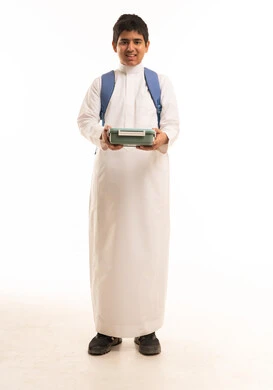طالب سعودي بالثوب التقليدي يحمل صندوق غداء مدرسي