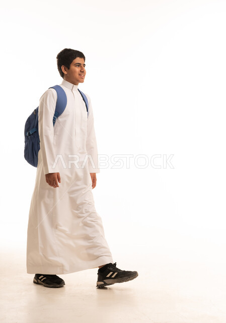 طالب سعودي يمشي بالثوب الأبيض وحقيبة الظهر