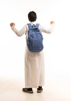 طالب سعودي يرتدي الثوب وحقيبة مدرسية يرفع يديه