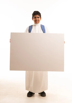 طالب سعودي يمسك بلوحة بيضاء فارغة في الاستوديو