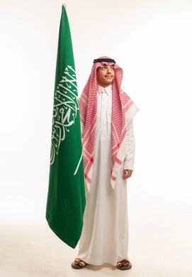 شاب سعودي يحمل علم المملكة العربية السعودية