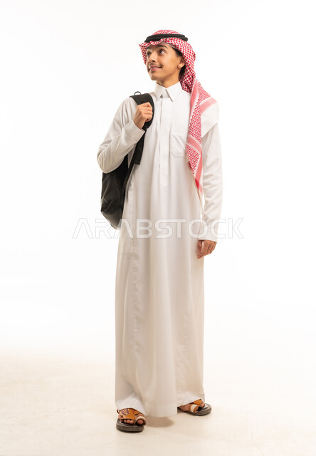 طالب سعودي بالزي التقليدي يحمل حقيبة ظهر