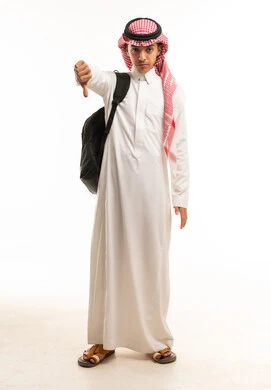 طالب سعودي يرتدي الثوب وحقيبة الظهر يشير بعدم الإعجاب