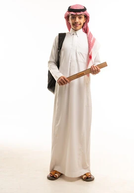 طالب سعودي بالثوب التقليدي يمسك مسطرة خشبية