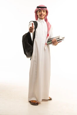 طالب سعودي بالزي التقليدي يحمل كتباً دراسية