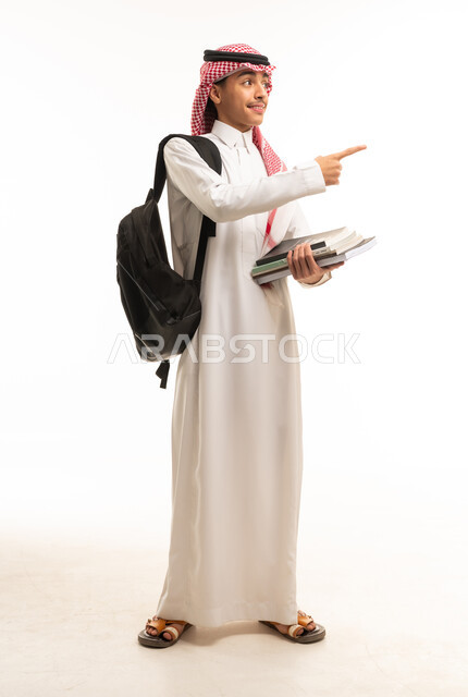 طالب سعودي بالثوب التقليدي يحمل كتب وحقيبة ظهر