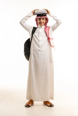 طالب سعودي بالزي التقليدي يحمل كتباً فوق رأسه