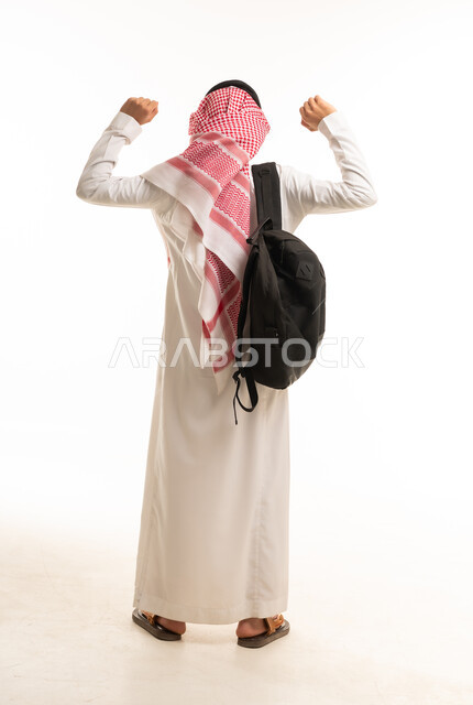 رجل سعودي مع حقيبة ظهر يرفع ذراعيه من الخلف