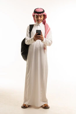 Saudi Student in Thobe Using Smartphone with Backpack