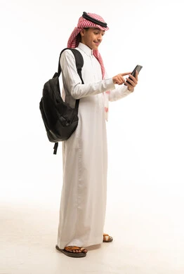 طالب سعودي يستخدم الهاتف الذكي مع حقيبة ظهر