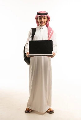 طالب سعودي بالزي التقليدي يحمل جهاز حاسوب محمول