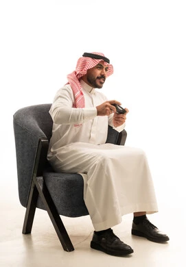 Saudi Man Playing Video Games in Traditional Thobe