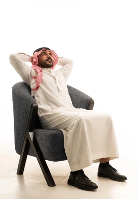 Saudi Man in Traditional Dress Relaxed in Armchair