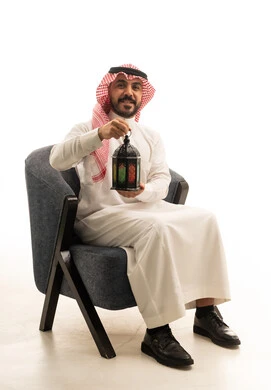 رجل سعودي بالزي التقليدي يحمل فانوس رمضان