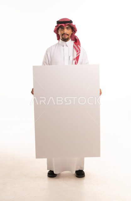 Saudi Man in Traditional Attire Holding Blank White Board