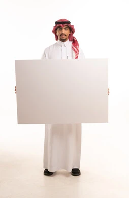 رجل سعودي يحمل لوحة بيضاء فارغة للإعلانات والتسويق