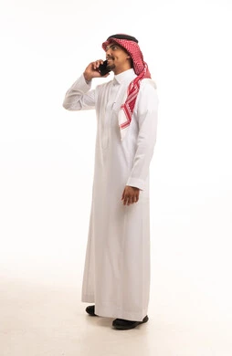 رجل سعودي بالزي التقليدي يتحدث عبر الهاتف الذكي