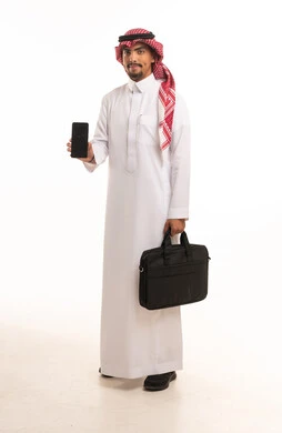 رجل أعمال سعودي يحمل هاتف ذكي وحقيبة لابتوب