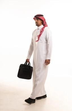 رجل أعمال سعودي بالثوب التقليدي يحمل حقيبة عمل