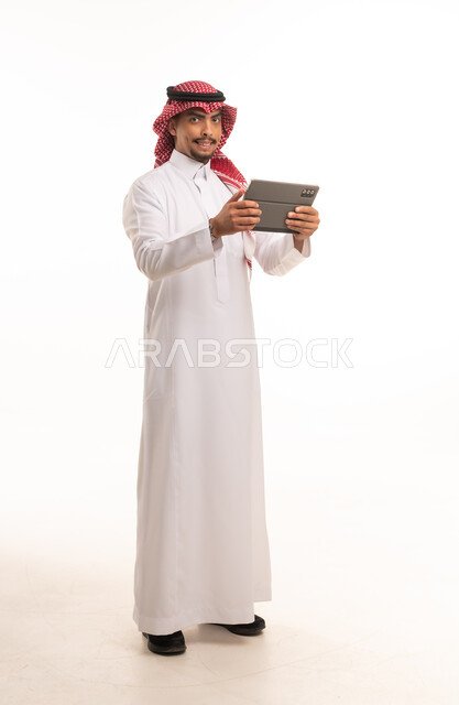 Saudi Man in Traditional Dress Using Digital Tablet