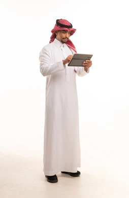 Saudi Man in Traditional Dress Using Digital Tablet