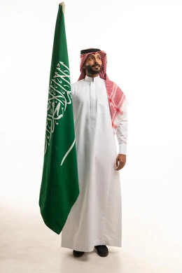 Saudi Man Holding National Flag in Traditional Dress
