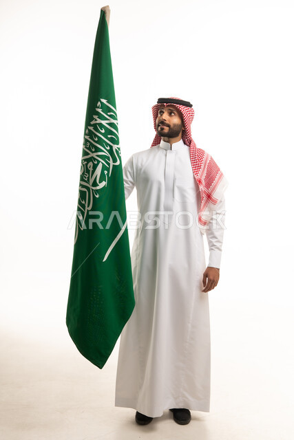Saudi Man in Traditional Dress Holding Saudi Arabia Flag