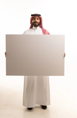 رجل سعودي يمسك بلوحة بيضاء فارغة في الاستوديو