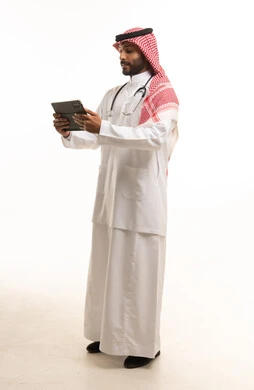 طبيب سعودي يرتدي السماعة الطبية ويستخدم الجهاز اللوحي