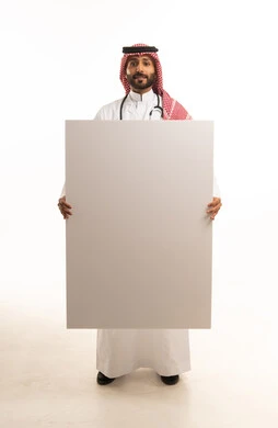 طبيب سعودي يمسك لوحة بيضاء فارغة للإعلان