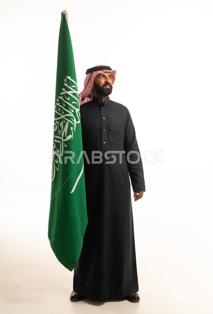 رجل سعودي يحمل العلم السعودي في الاستوديو