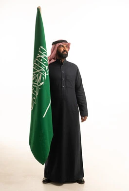 رجل سعودي يحمل العلم السعودي في الاستوديو