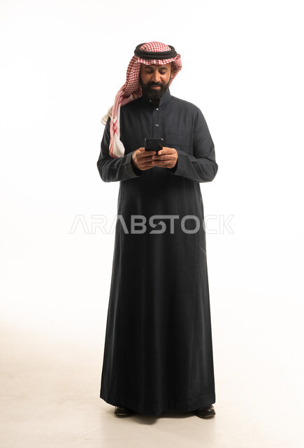 Saudi Man in Black Thobe Using Smartphone Studio
