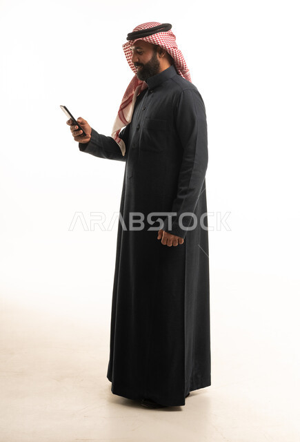 Saudi Man in Black Thobe Using Smartphone