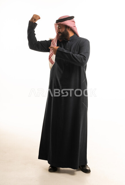 رجل سعودي يستعرض عضلاته بالزي التقليدي