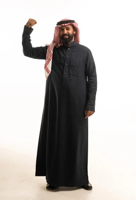 رجل سعودي بالزي التقليدي يرفع قبضته بقوة