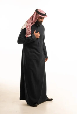 رجل سعودي بالزي التقليدي والثوب الداكن بخلفية بيضاء