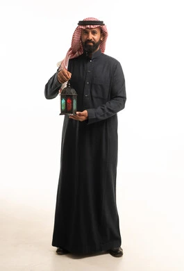 Saudi Man in Traditional Thobe Holding Ramadan Lantern