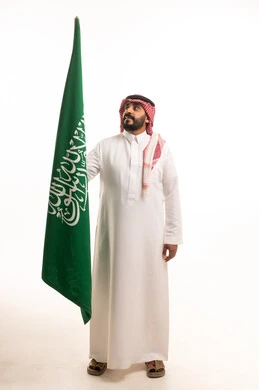 رجل سعودي يرفع العلم الوطني السعودي في الاستوديو