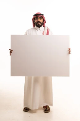 رجل سعودي يحمل لوحة بيضاء فارغة في الاستوديو