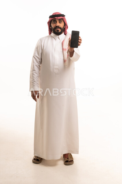 رجل سعودي يحمل هاتف ذكي بخلفية بيضاء