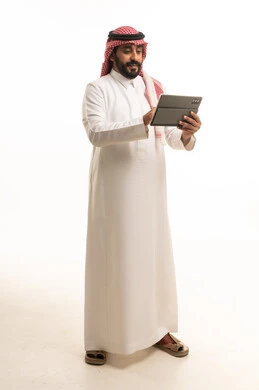 رجل سعودي يستخدم جهاز لوحي على خلفية بيضاء