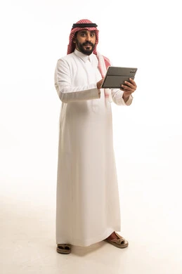رجل سعودي مع جهاز لوحي بالزي التقليدي