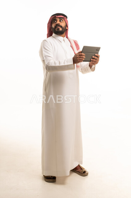 Saudi Man in Traditional Thobe Holding Digital Tablet