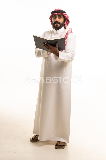 رجل سعودي يمسك كتاباً أمام خلفية بيضاء