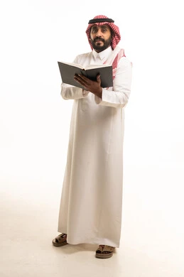 رجل سعودي يمسك كتاباً أمام خلفية بيضاء