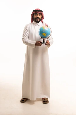 رجل سعودي بالزي التقليدي يحمل مجسماً للكرة الأرضية
